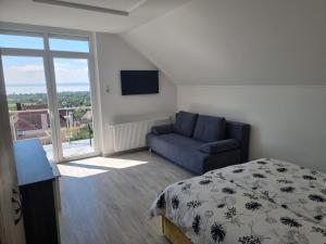 a bedroom with a bed and a couch and a tv at Lakeview Apartments Balatonfüred in Balatonfüred
