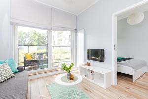 ワルシャワにあるSuperApart Światowida 16 - Białołęka z parkingiemの白いリビングルーム(ベッド1台、テレビ付)