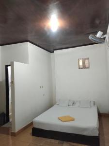 a bedroom with a white bed with a ceiling at Vacation Inn Gili in Gili Trawangan +4 photos