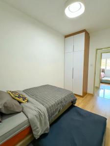 ein Schlafzimmer mit einem Bett und einem weißen Schrank in der Unterkunft Peony Apartment Cameron Highland in Kampung Kuala Terla + 33 Fotos