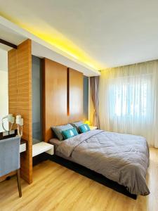 ein Schlafzimmer mit einem großen Bett mit blauen Kissen in der Unterkunft Peony Apartment Cameron Highland in Kampung Kuala Terla