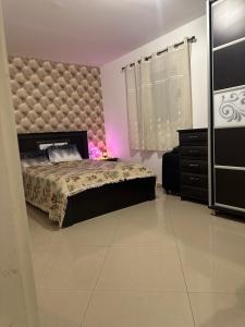 a bedroom with a large bed and a dresser at מיני סוויטה לה פלמורה in Eilat