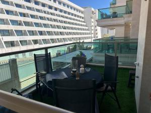 a table and chairs on a balcony with a large building at מיני סוויטה לה פלמורה in Eilat