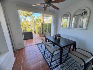 jadalnia ze stołem i krzesłami oraz wentylatorem sufitowym w obiekcie Townhouse beachfront in Costalita w mieście Estepona