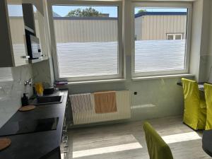 a kitchen with two windows and a counter top at Penzion Teplanka in Považská Bystrica +11 photos