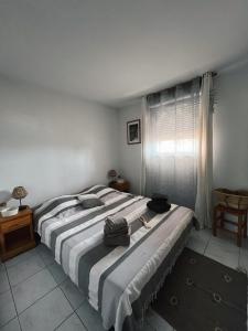 a bedroom with a large bed with two bags on it at Location appart 2 pièces a Agay in Saint-Raphaël