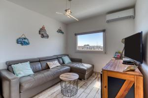a living room with a couch and a flat screen tv at Marina Port Camargue in Le Grau-du-Roi