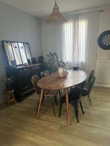 une salle à manger avec une table et des chaises en bois dans l'établissement Jolie mancelle proche centre (idéal 24h du Mans), au Mans
