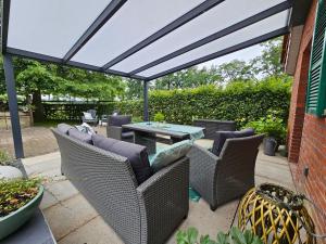 a patio with wicker chairs and a table at Kleines Ferienhaus Luettje Backhuus 35516 in Uplengen