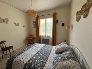a bedroom with a bed and a window with butterflies on the wall at Cabane Meysouet-maison refaite à neuf vélo Bourg in Mimizan