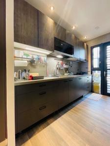 a kitchen with brown cabinets and a sink and a counter at 萊恩晴旅包棟民宿 in Magong +28 photos