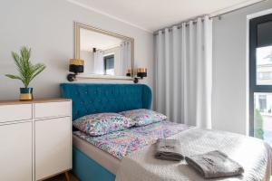 a bedroom with a blue bed and a mirror at Mi Bella II in Gdynia