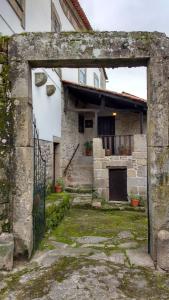 einen Eingang zu einem Steinhaus mit einem Tor in der Unterkunft Casa Grande - Casas de Campo na Serra da Estrela in Paços da Serra