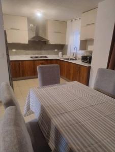 a kitchen with a table and two chairs and a kitchen with a sink at Linda Casa in Acayuca