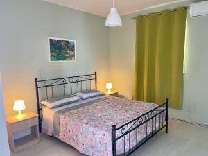 a bedroom with a bed and two tables with lamps at Leverblu House in Marina dʼAvola