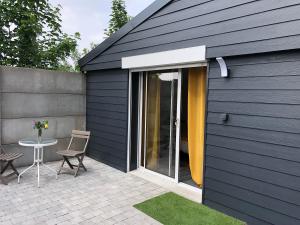 a black house with a patio with a table and chairs at Hébergement 2 personnes in Illies