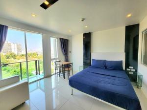 a bedroom with a blue bed and a table with chairs at Nice studio comfortable in Pattaya Central +9 photos