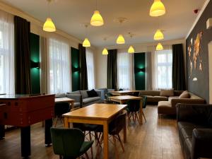 a waiting room with tables and couches and chairs at Hostel Waltz in Bratislava
