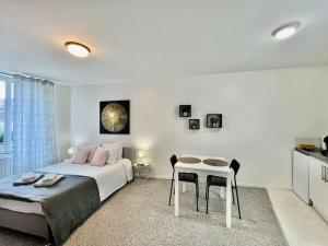 a bedroom with a bed and a table in it at Studio 3 Rue Théodore Bac - DABNB in Limoges +1 photo