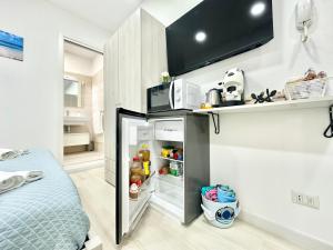 a small kitchen with a refrigerator and a microwave at Ale & Andry House in Cefalù