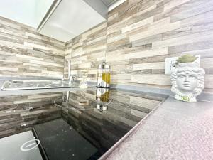 a bathroom with a glass table and a statue at Ale & Andry House in Cefalù +23 photos