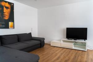 a living room with a couch and a flat screen tv at Monteurswohnung nähe Mainz 5 Schlafzimmer in Gabsheim