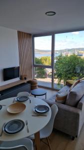 a living room with a table and a couch at Apartamentos Puerto Camariñas in Camariñas