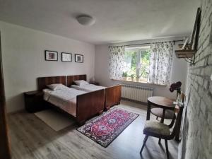 a bedroom with a bed and a table and a window at Siedlisko pod Orzechem in Przyłęk