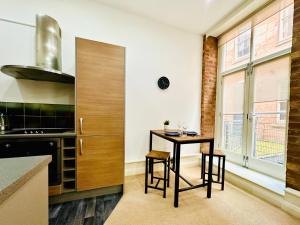 a kitchen with a table and chairs in a room at Lovely modern Studio in the Heart of City Centre in Nottingham