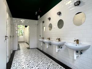 a bathroom with three sinks and mirrors on the wall at Hostel Waltz in Bratislava +50 photos