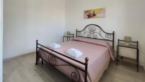 a bedroom with a bed with pink sheets and two night stands at Villetta Gioia in Torre Lapillo