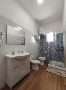 a bathroom with a sink and a toilet and a shower at Villetta Gioia in Torre Lapillo