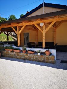 a wooden pavilion with potted plants on a patio at Apartma Ester in Lucija