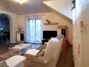 a living room with a white couch and a table at Lake House Apartment in Medvode