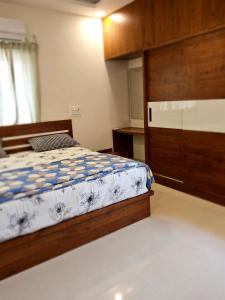 a bedroom with a bed and a wooden cabinet at VEDHA Homestay in Tirupati +4 photos