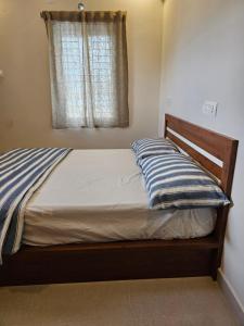 a bed with a wooden frame and a window at VEDHA Homestay in Tirupati