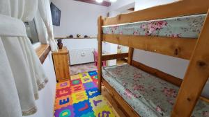 LotrioaraにあるCarla Maria Houseのベッドルーム1室(二段ベッド2台、ラグ付)