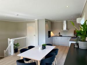 Una cocina y un comedor con una mesa y sillas blancas. en Bo moderne på Falkum med utsikt, en Skien