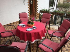 a red table and chairs on a patio at FerienResidenz M.J.S. Blanctanneur in Ramberg