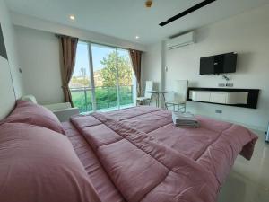 a large bed in a room with a large window at Studio apartment in nice in Pattaya Central