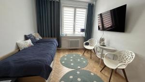 a bedroom with a bed and a table and chairs at Apartament Rodzinny Nad Morzem, Gdynia in Gdynia