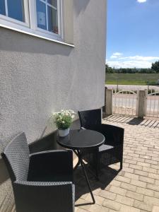 eine Terrasse mit Tisch und Stühlen und einem Tisch mit Blumen in der Unterkunft Harmonie in Landskrona