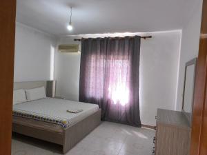 a small bedroom with a bed and a window at Green Haven Cottage in Delvinë