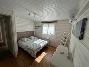 a small bedroom with a bed and a window at Maison MAHECO in Gujan-Mestras