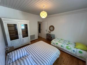 a bedroom with a bed and a pendant light at Maison MAHECO in Gujan-Mestras