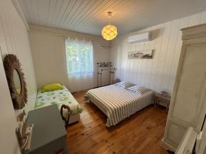 a bedroom with two beds and a table in it at Maison MAHECO in Gujan-Mestras