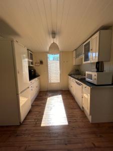 a kitchen with white cabinets and a white refrigerator at Maison MAHECO in Gujan-Mestras
