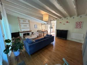 a living room with a blue couch and a fireplace at Maison MAHECO in Gujan-Mestras