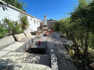 a patio with a couch and an umbrella at Maison MAHECO in Gujan-Mestras