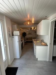 a kitchen with white appliances and a ceiling at Maison MAHECO in Gujan-Mestras
